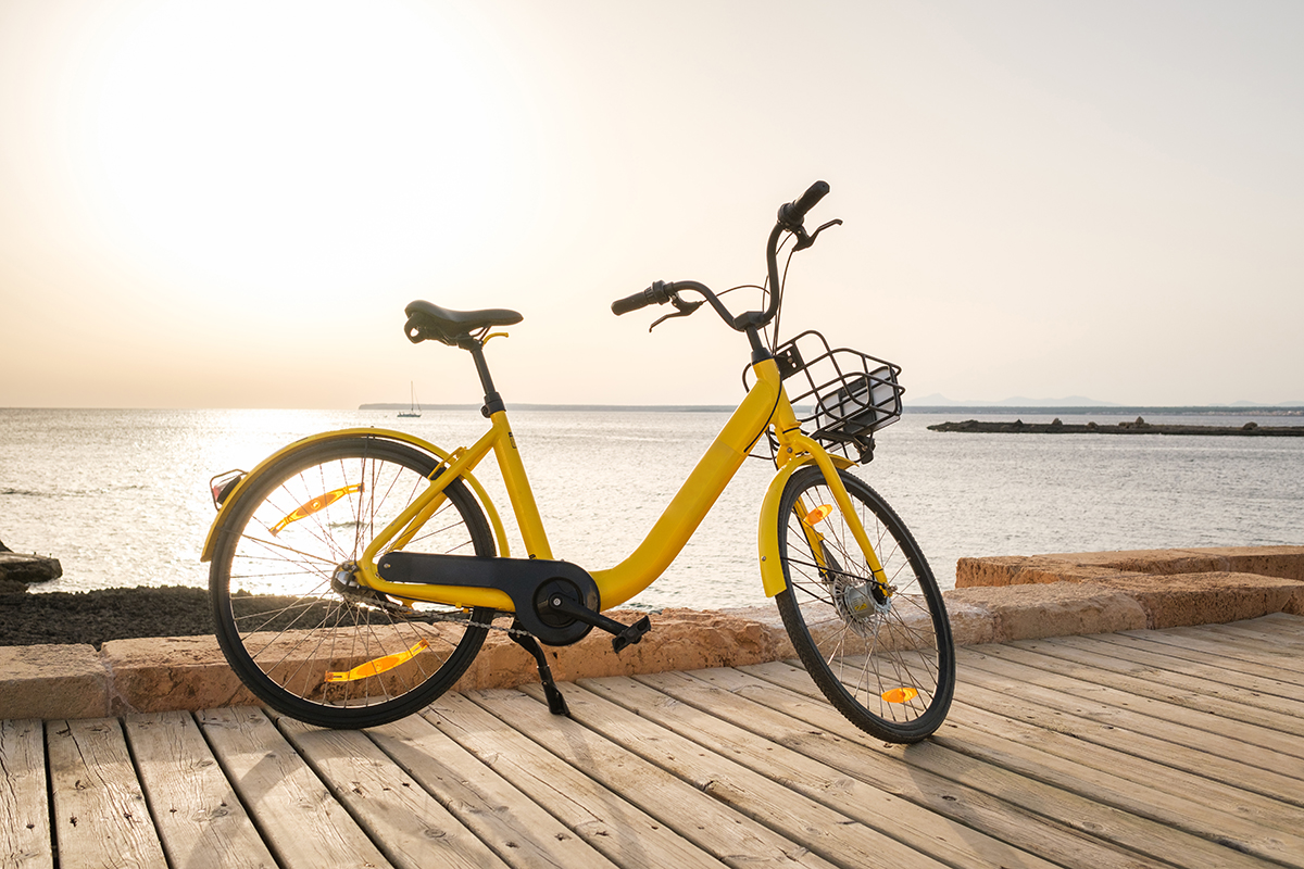 Yellow rental bicycle parked on embankment